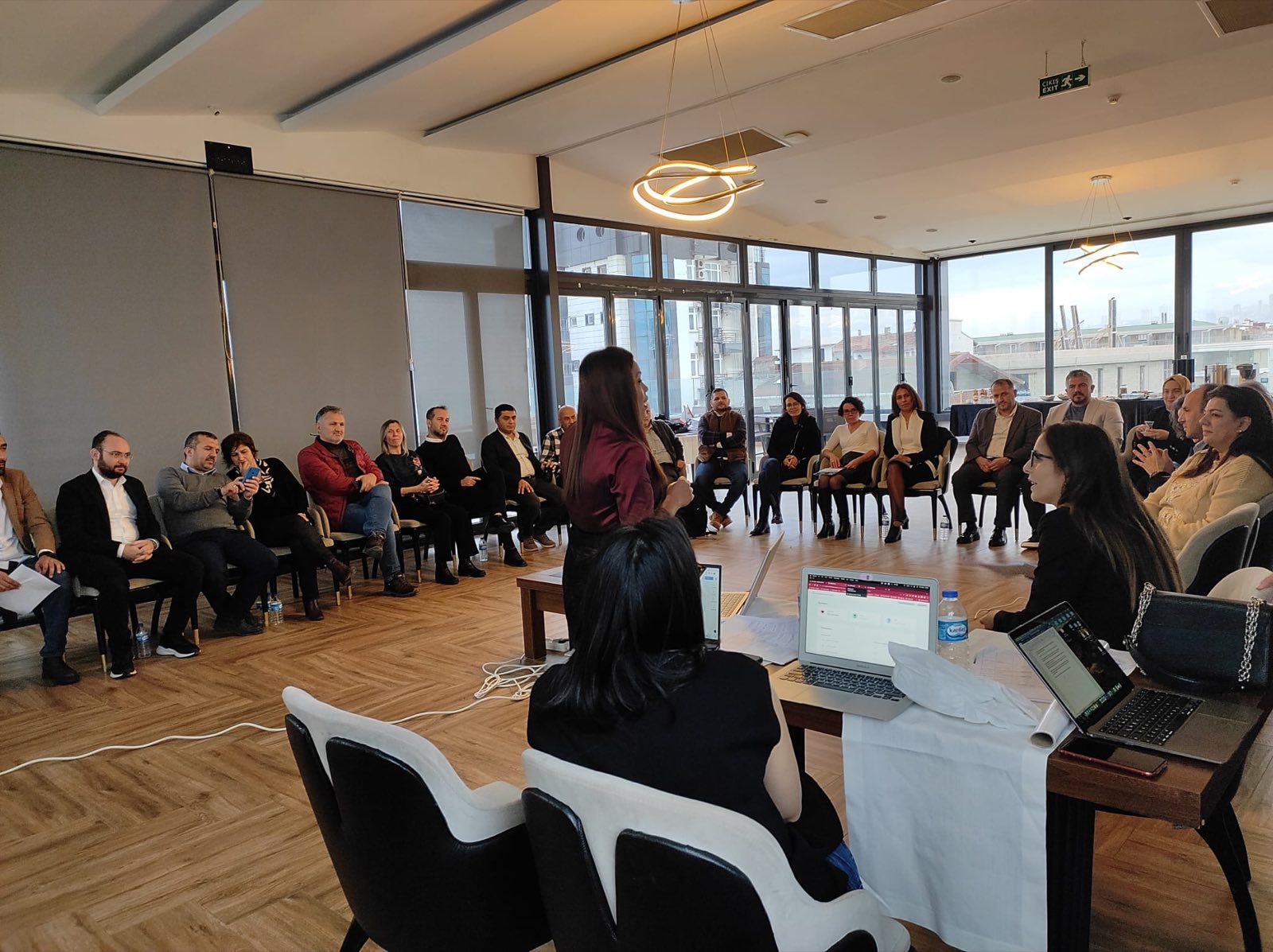 Ananya Tiwari facilitating a large discussion circle of stakeholders in a bright room in Samsun, Turkey